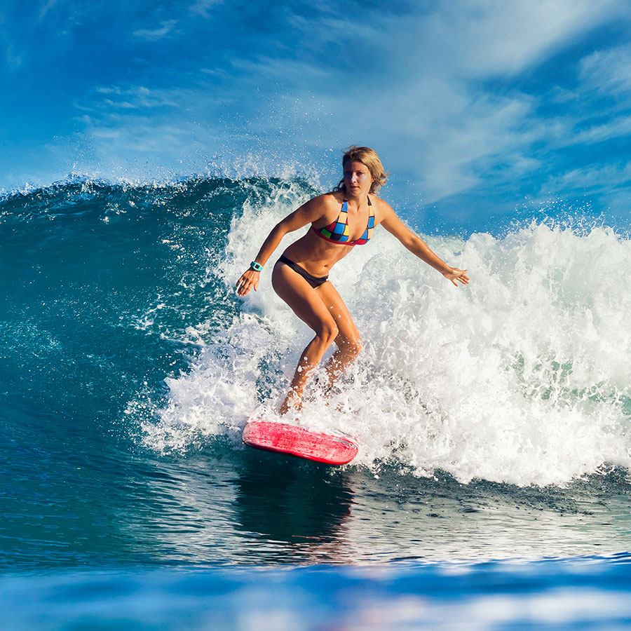 female-surfer-on-a-blue-wave-PJV6P9B.jpg